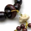 A dark brown wooden lotus-carved bracelet with small beaded tassels Application Scenario